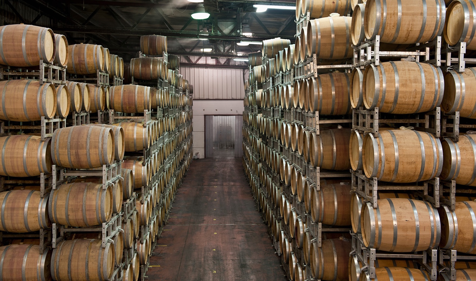 Rows of maturing whisky casks stacked in a bonded warehouse